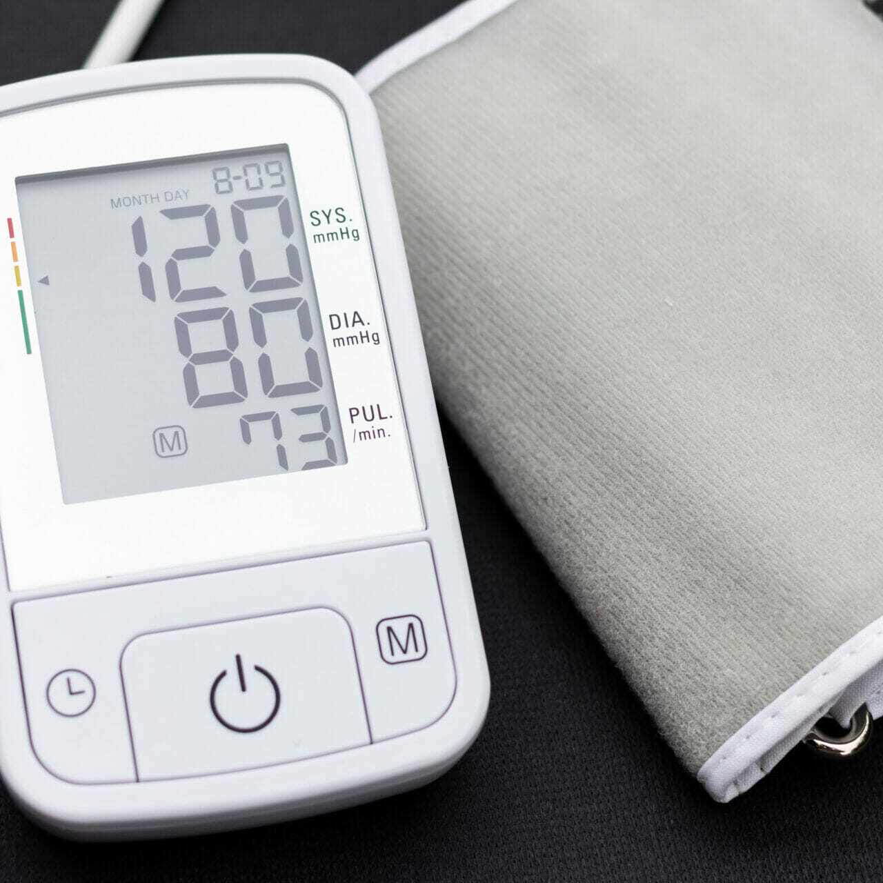 Automatic blood pressure monitor with normal blood pressure 120/80 readings on a black background